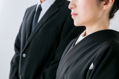 喪服姿で並ぶ男女